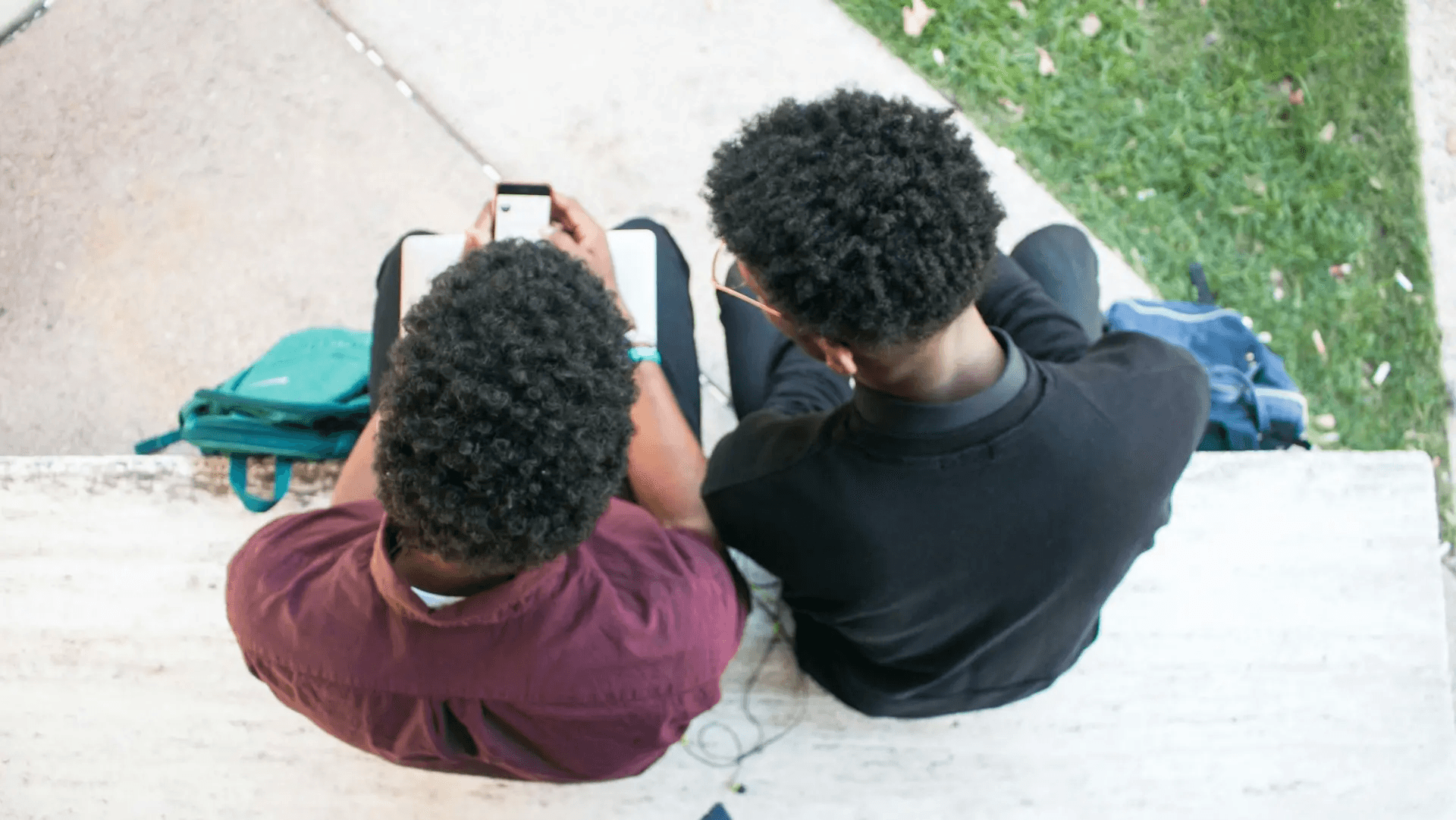 Two people using a phone outdoors