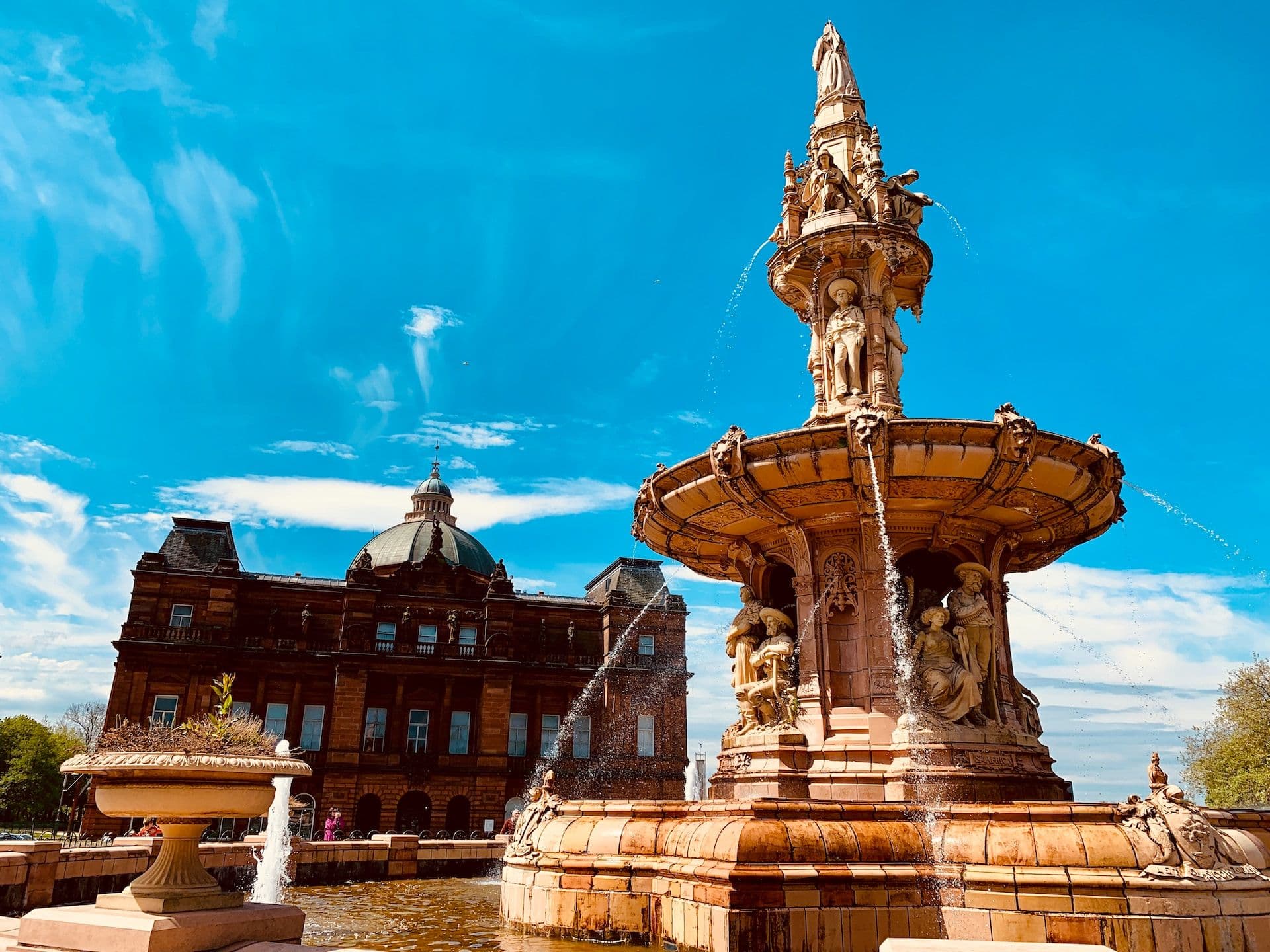 water fountain outside castle under blue sky