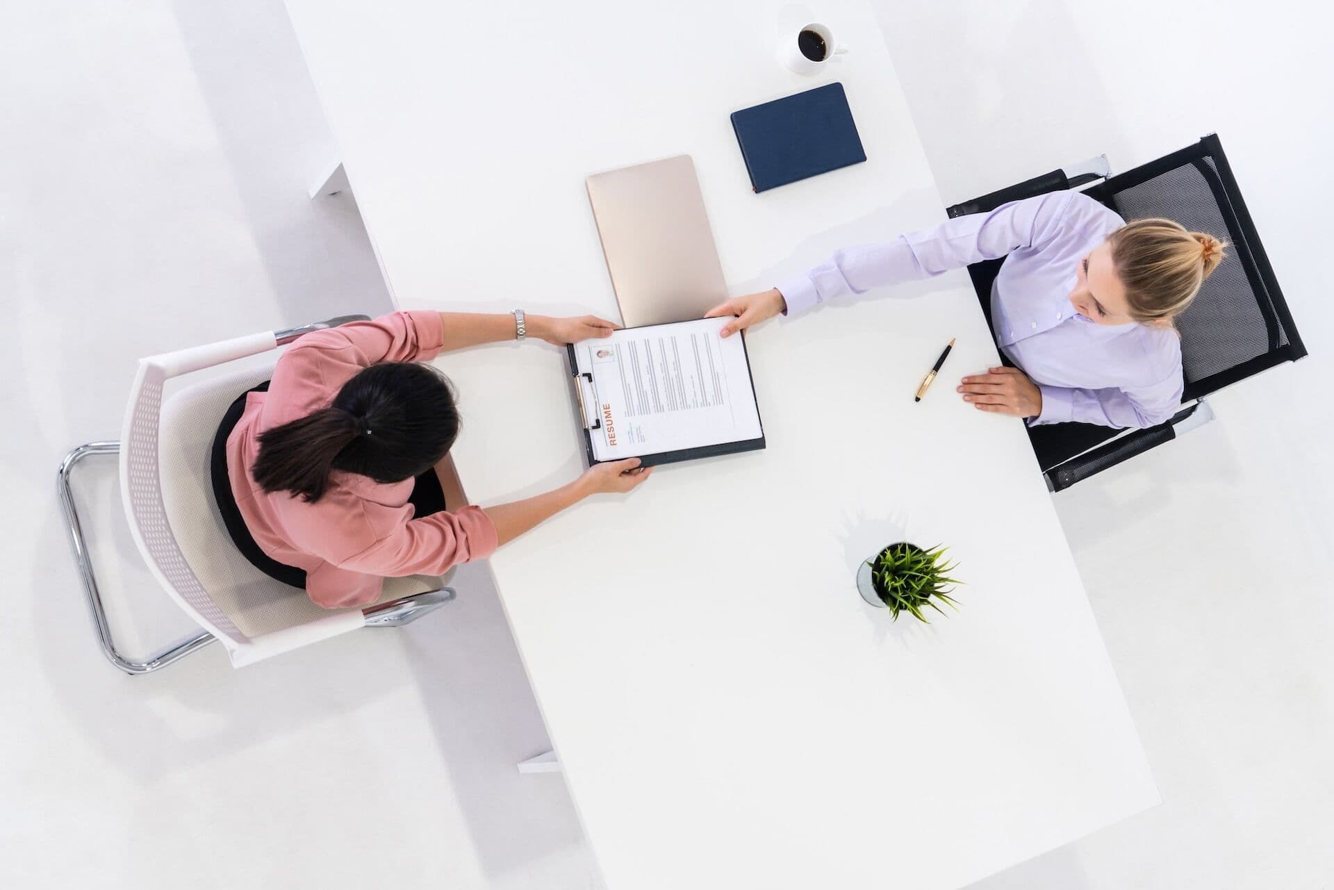 Two young business women in meeting at office table for job application and business agreement