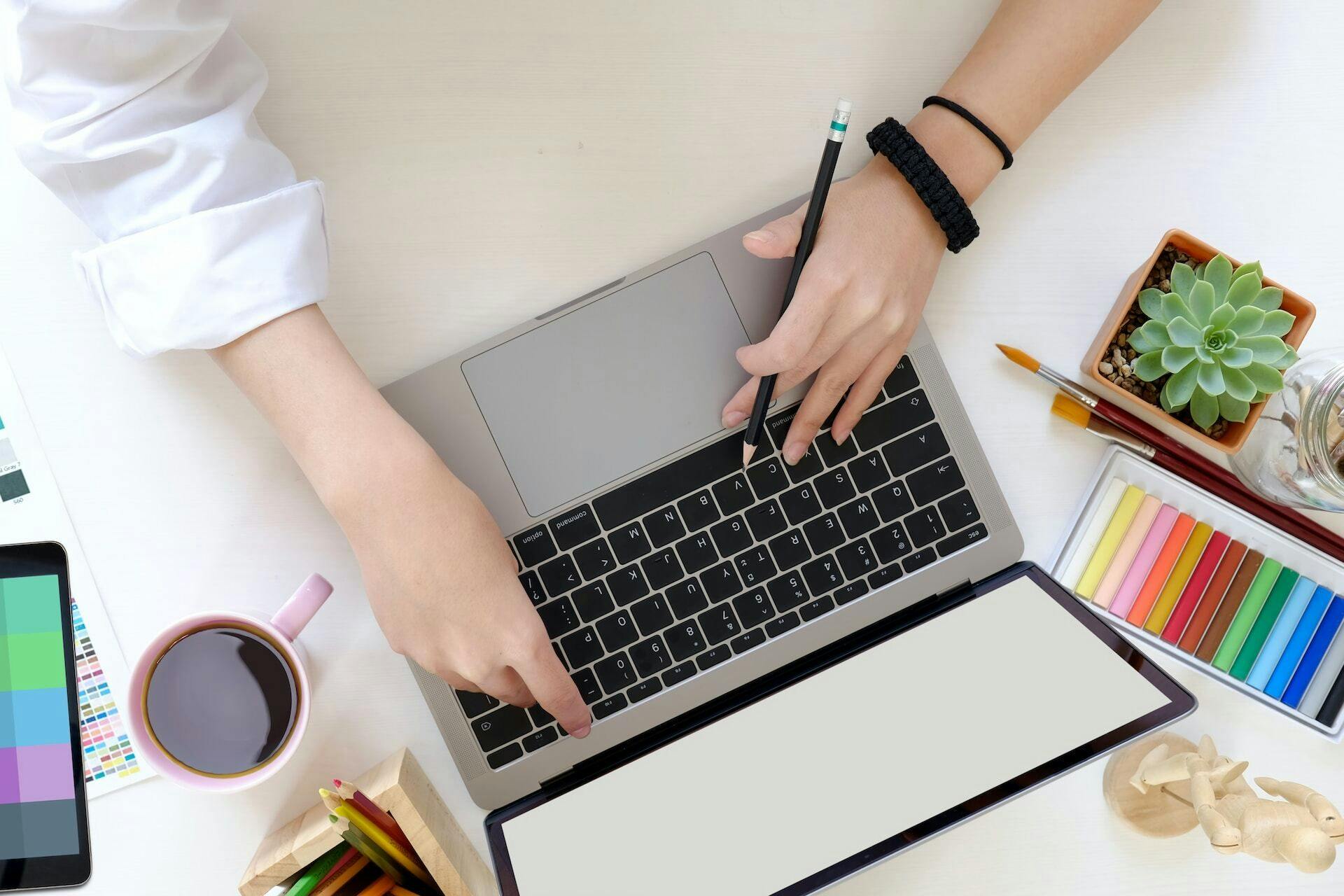 Female designer using laptop at creative studio desk