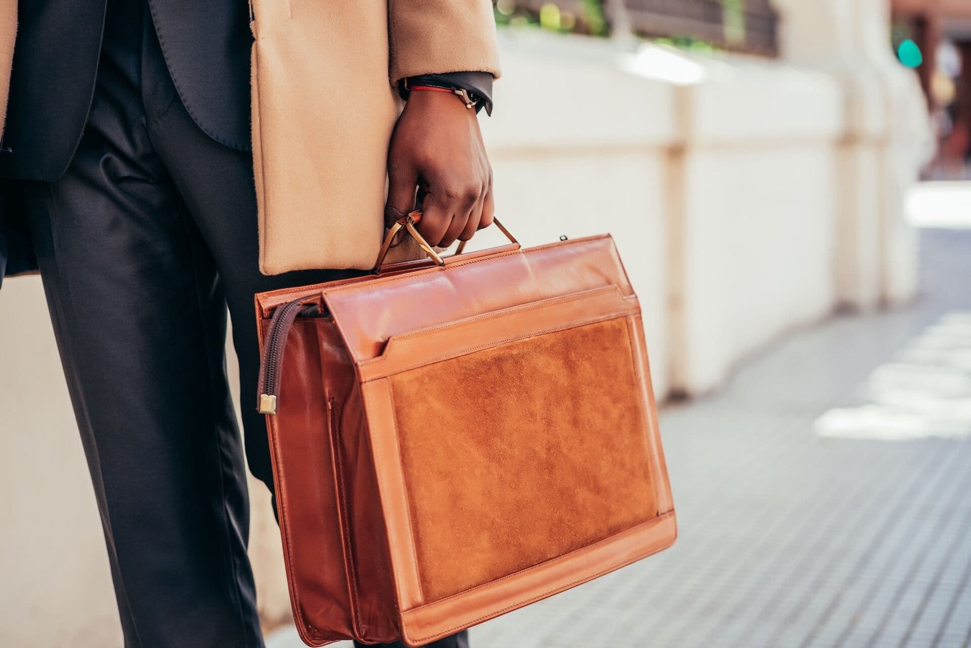 Man holding briefcase on road during daytime