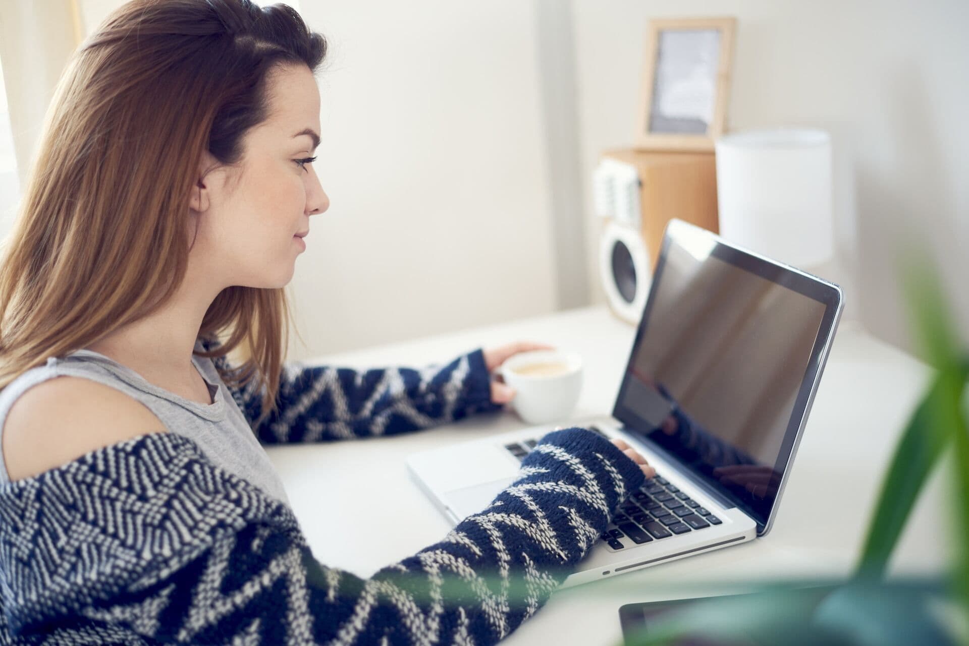 girl sitting in living room and using laptop in the morning